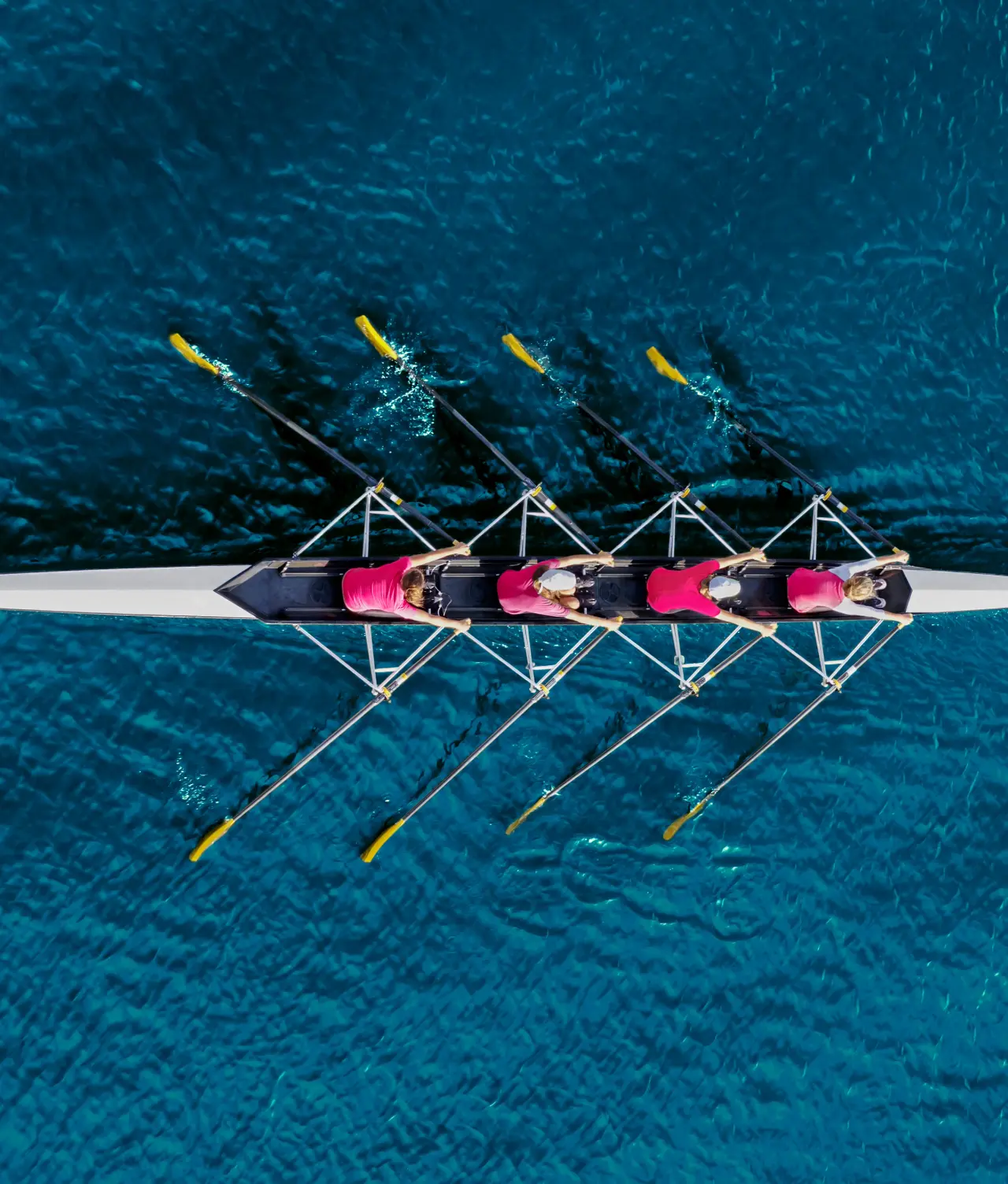 Aerial view of a rowing crew moving in unison on open water
